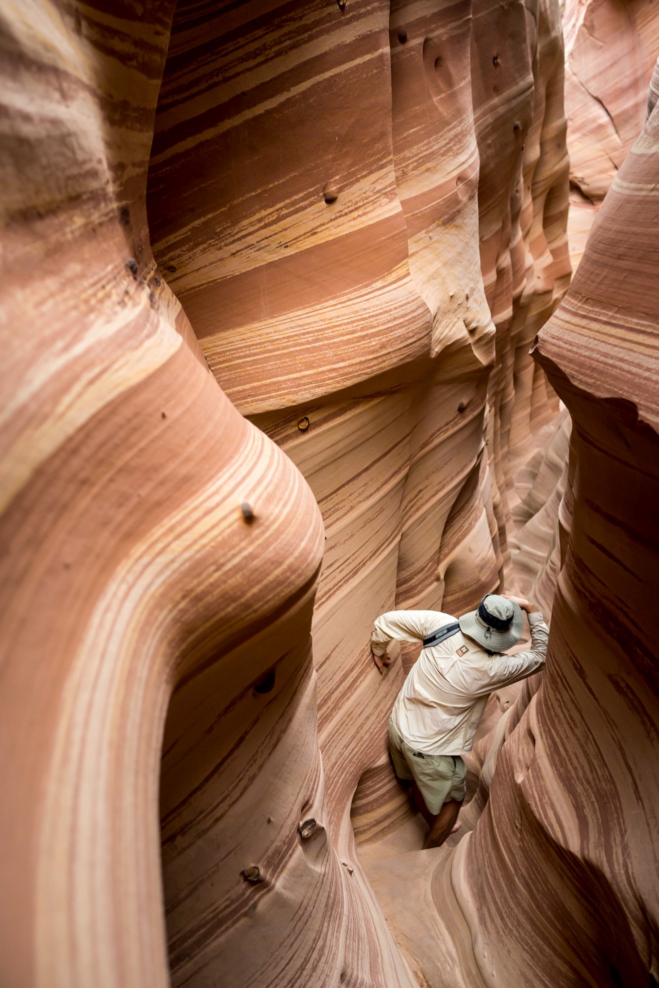 a hiker walks through a slot canyon in Escalante National Monument