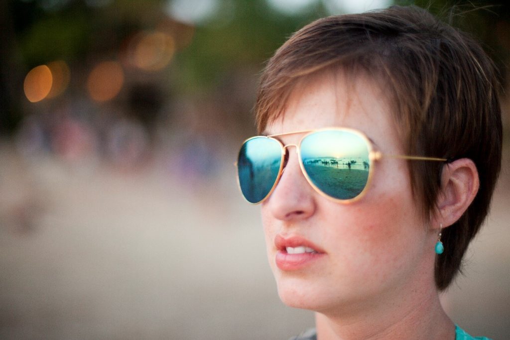 a portrait of a girl with reflections of boats in her sunglasses