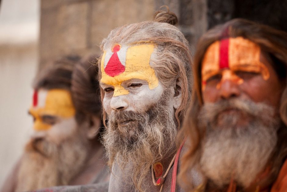 intriguing holi men with painted faces sit on the steps of a temple in kathmandu nepal
