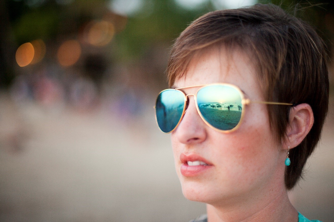 a portrait of a girl with reflections of boats in her sunglasses