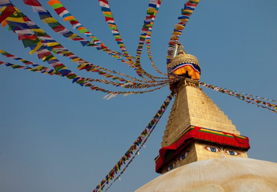 a stupa at a nepalese temple displays characteristic eyes and prayer flags
