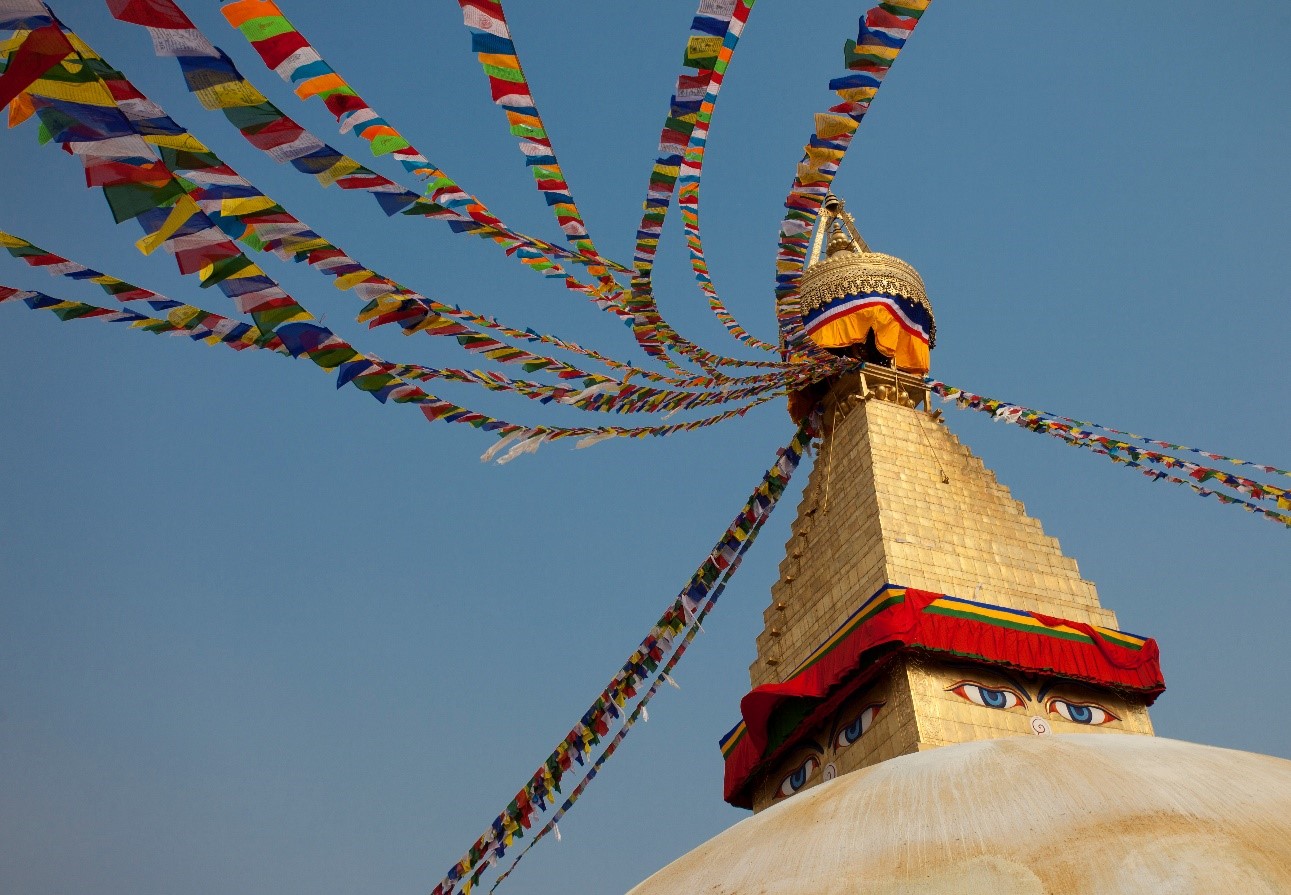 a stupa at a nepalese temple displays characteristic eyes and prayer flags