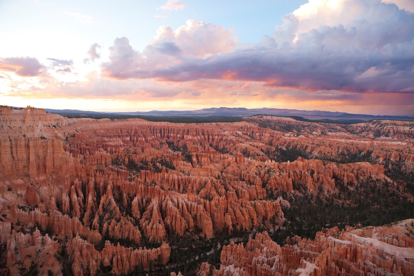 a colorful sunset emerges over the rim of bryce canyon national park
