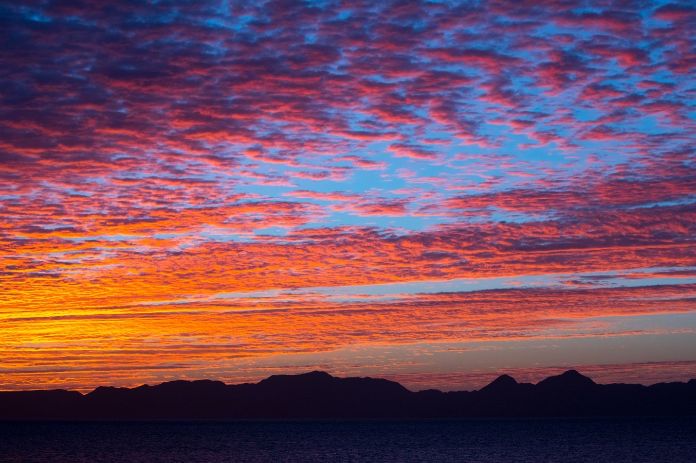 a sunset shimmers over the mountains in baja
