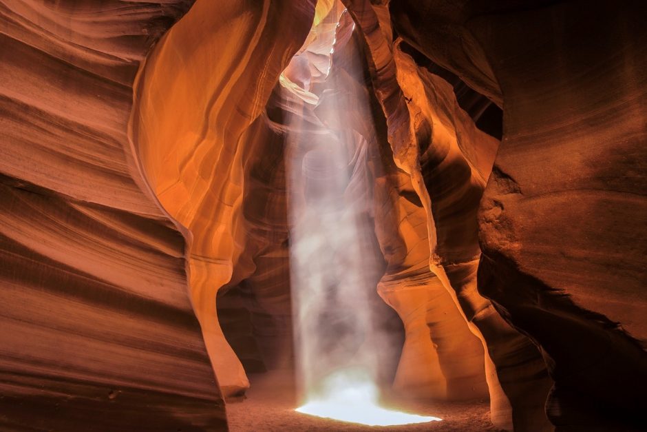 a beautiful sun beam pierces through antelope canyon