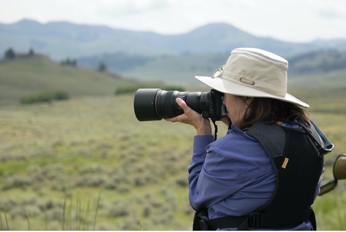 a woman photographs with a telephoto lens in Yellowstone National Park