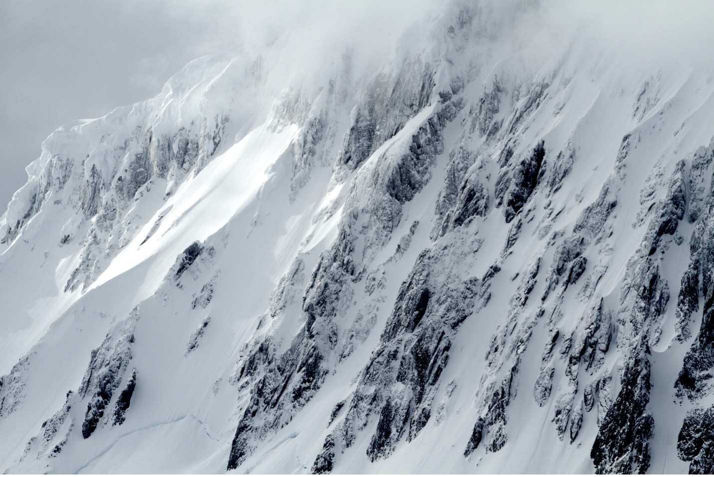 a highly textured mountain fills the frame from a range in Antarctica