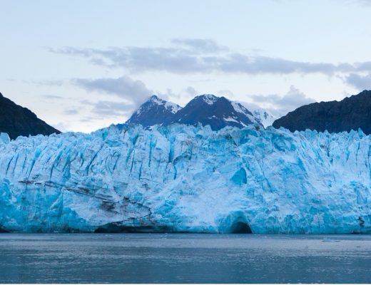a beautiful blue glacier spans edge to edge in the frame