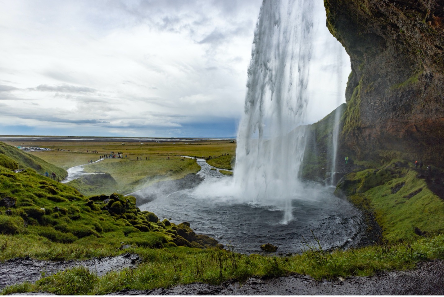 a towering waterfall splashes in front of the camera