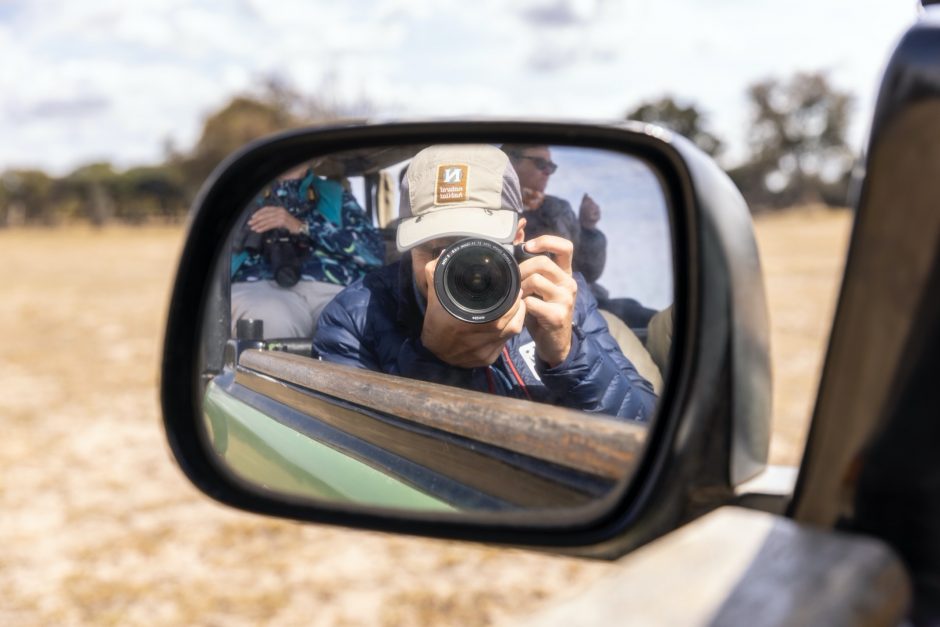 a photographer's self portrait in a rear view mirror