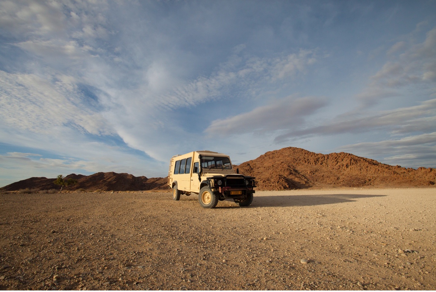 a single truck in the deserts of Namibia with big blue sky overhead