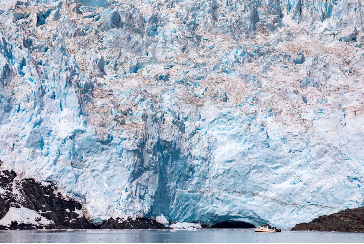 a glacier towers over the water