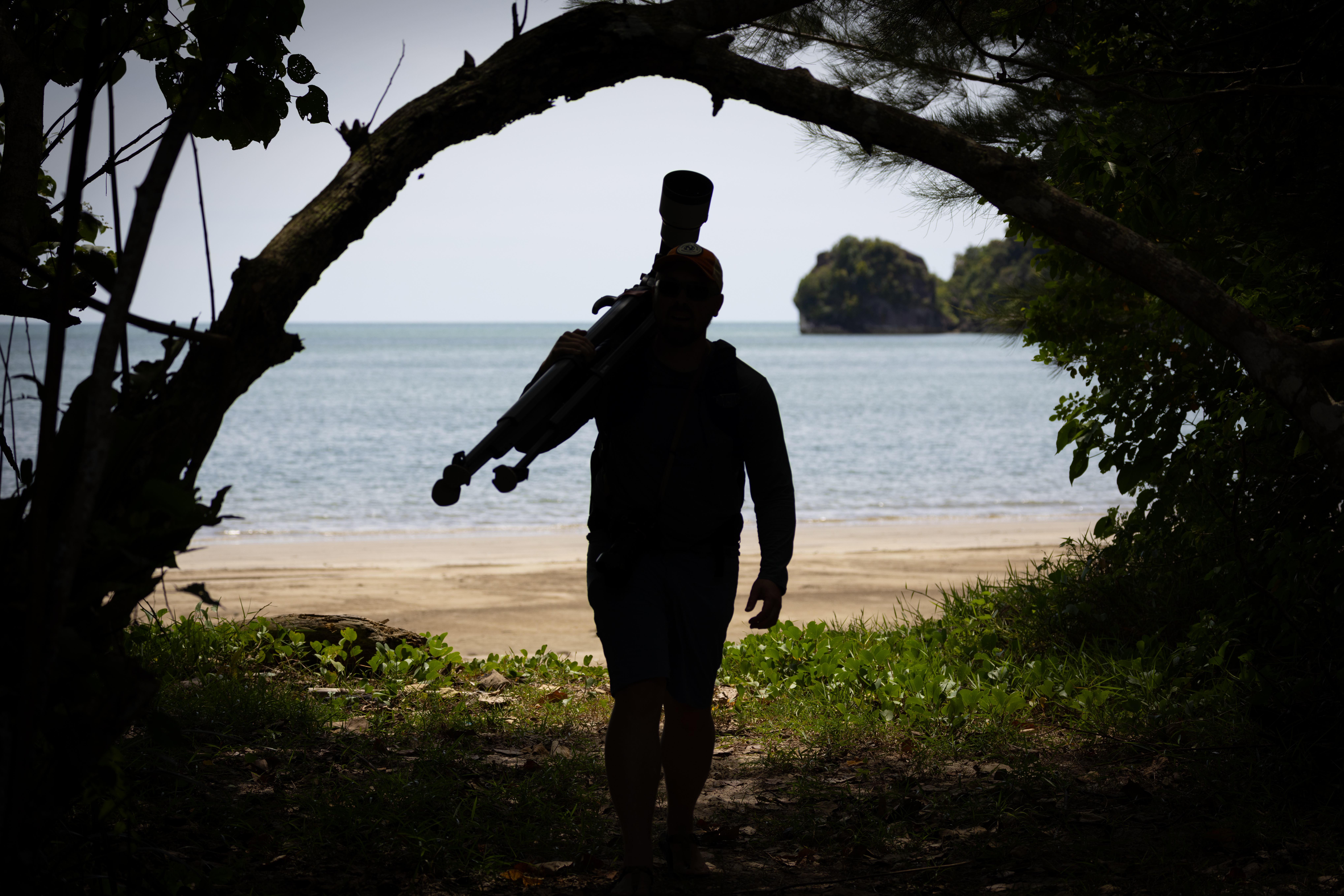 a photographer walks through dim light