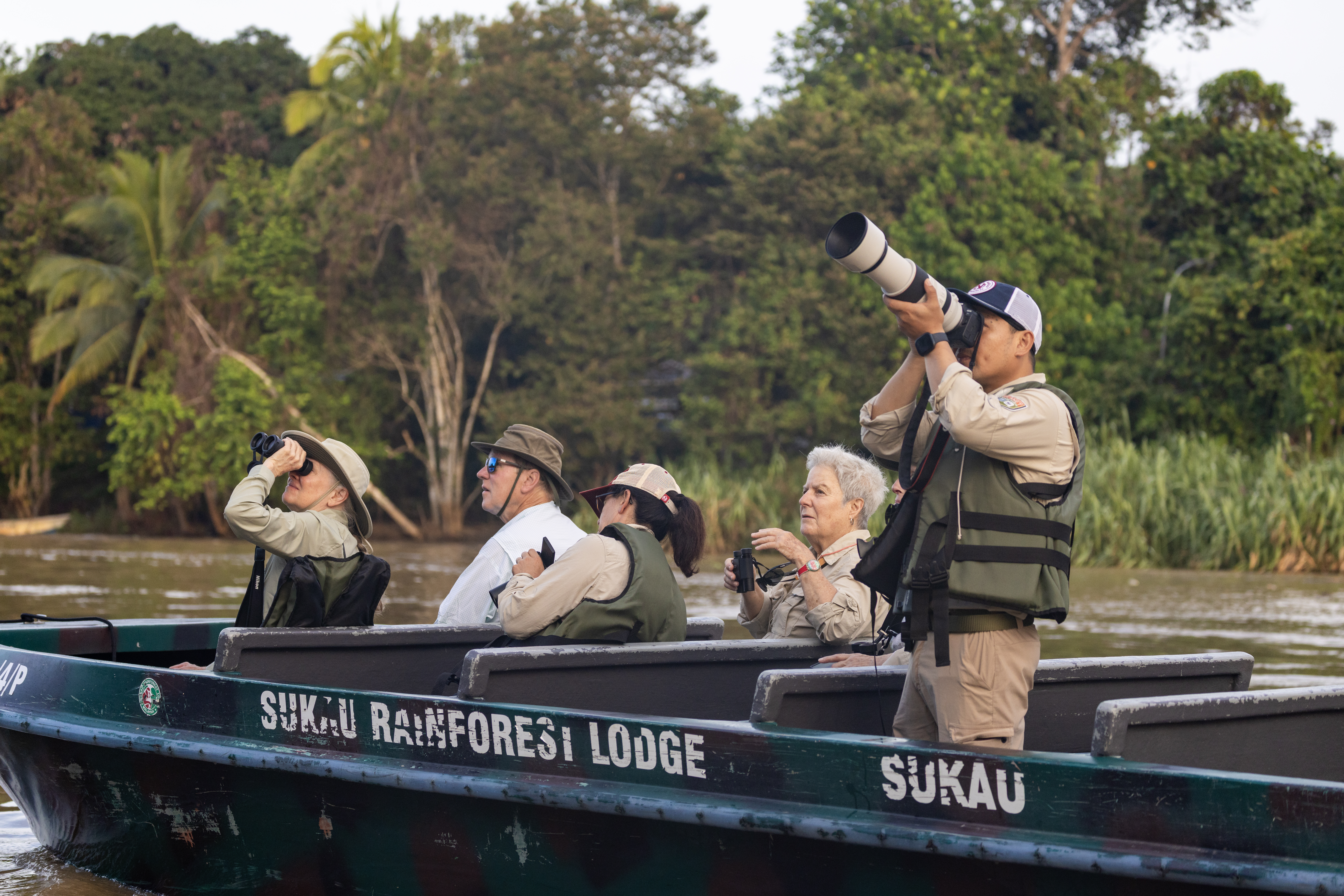 photographers peer from a boat in Borneo