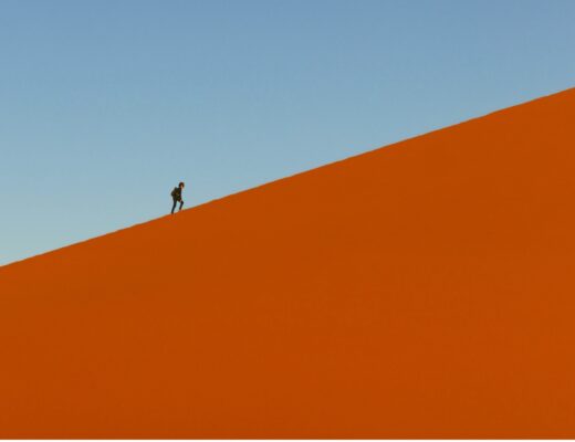 a hiker walks on top of a dune in Namibia